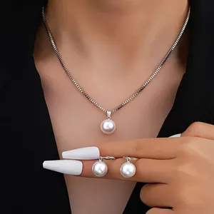 Elegant pearl jewelry set with necklace and stud earrings on dark professional attire