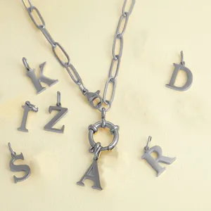 Close-up of silver OT buckle chain necklace with various alphabet letter charms