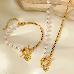 Detail-Set aus goldener Box-Kette und Perlenkette mit M-Herzanhänger und OT-Verschluss