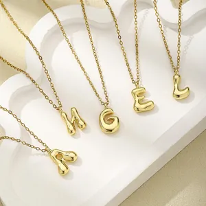 Details der 18K vergoldeten Bubble-Buchstaben-Anhänger an eleganten feinen Ketten