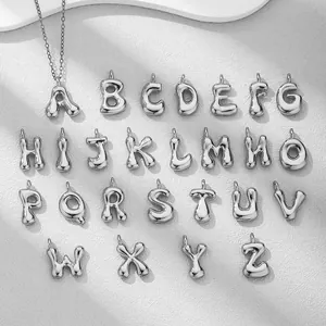 Makroaufnahme von 18K vergoldeten Puffy-Alphabet-Anhängern mit poliertem Spiegel-Finish
