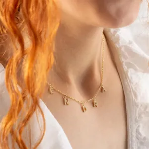Nahaufnahme der goldenen ENDRA Buchstabenkette mit Zirkonia an einem Modell