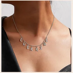 Detail einer silbernen Edelstahlkette mit einem mikroverzierten CHERRINE-Buchstabenanhänger