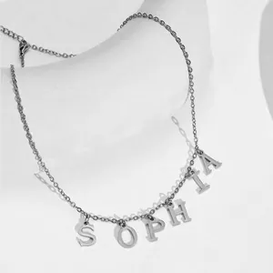 Detail shot of silver SOPHIA letter necklace with lobster clasp on geometric display
