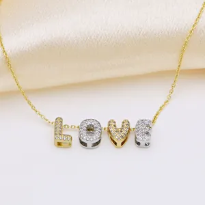 Detail of LOVE pendant necklace with micro-pave zircons on gold and silver letters