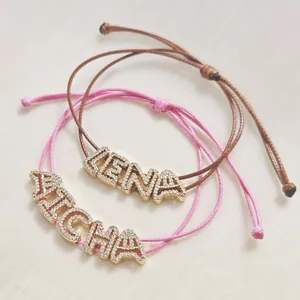 Adjustable woven letter bracelets in pink and brown with CZ micro-paved gold alphabet sliders