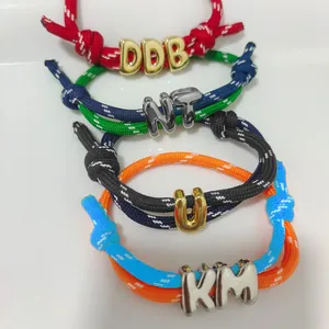 Colorful woven letter bracelets with adjustable cords and polished gold alphabet charms