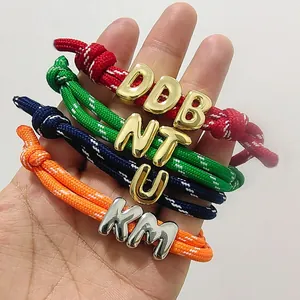 Colorful hand-woven letter charm bracelets with adjustable slip knots and metallic beads