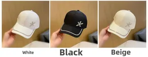 Dettaglio dei cappellini da baseball bianchi, neri e beige con stelle di strass e visiera lucida