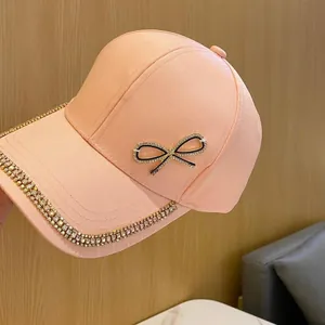 Détail du nœud en strass et bordure en cristal sur la casquette de baseball rose pêche
