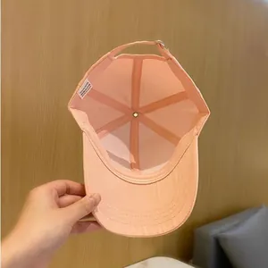 Vue détaillée de l'intérieur d'une casquette rose en polyester avec coutures et étiquette
