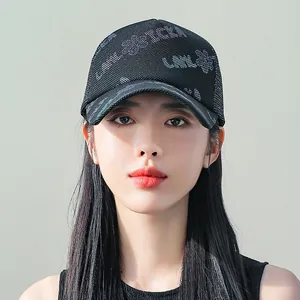 Dettaglio del cappellino da baseball in mesh nero con motivi floreali iridescenti sulla corona