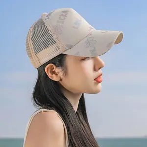 Dettaglio del retro in rete traspirante e del motivo floreale sul cappellino beige