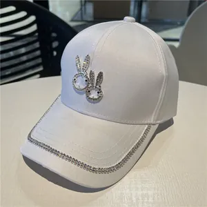 White baseball cap with rhinestone rabbit patterns and sparkling brim decorations
