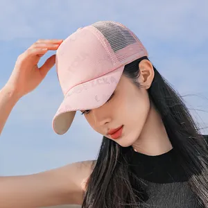 Vista dal basso di un cappellino da baseball in mesh rosa con motivi floreali dorati