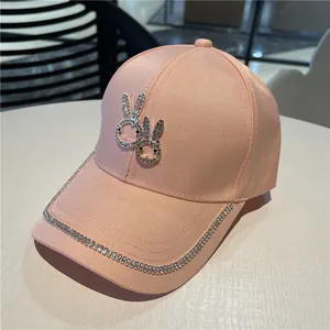 Pink satin baseball cap with sparkling rhinestone twin bunny icons and studded brim edge