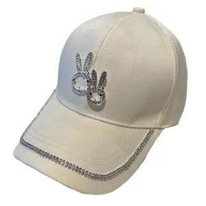 Cream satin baseball cap with rhinestone rabbit logo and embellished brim for women