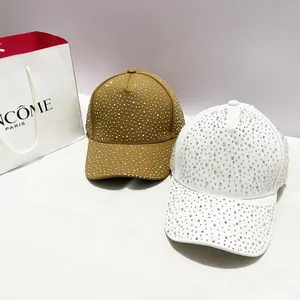 Detailopname van kaki en witte dames baseballpetten met volledige strass versieringen