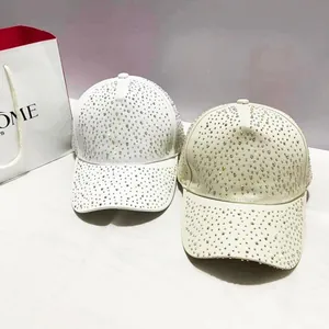 Detail van witte en beige honkbalpetten met volledige strass-inleg en glans