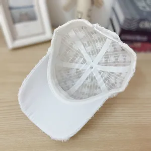 Detail view of white mesh baseball cap showing breathable inner fabric and structured shape