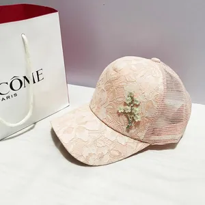 Détail de la casquette rose en dentelle florale avec maille fine et broderie de fleurs 3D