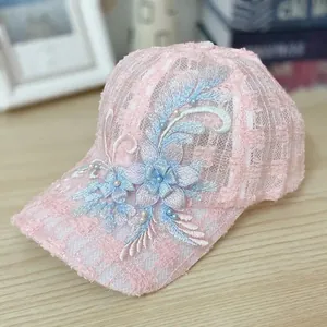 Close-up of pink lace baseball cap with floral embroidery and delicate pearl beads