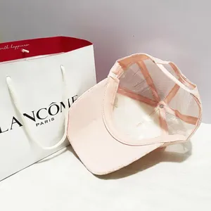 Détail de la casquette rose avec texture en maille respirante et boucle de réglage arrière