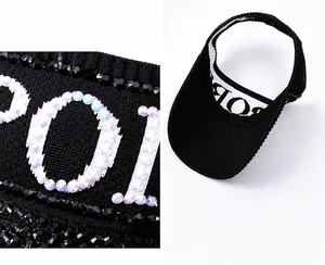Close-up detail of rhinestone SPORT lettering on black sun visor hat with inner lining