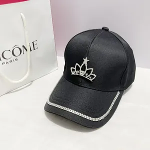 Dettaglio cappello nero con corona di strass e visiera decorata con brillantini