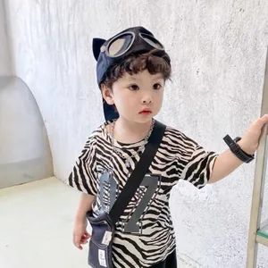 Detail of kids black aviator cap with goggles paired with a zebra print t-shirt
