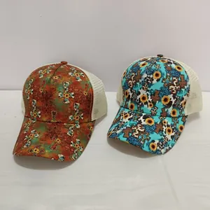 Detail of printed criss-cross ponytail trucker caps with floral cross and sunflower designs
