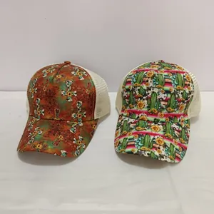 Detail view of two printed trucker hats with floral cross and cactus patterns and mesh back