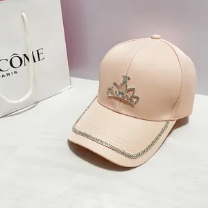 Dettaglio della corona di strass scintillanti su un cappellino da baseball rosa in cotone