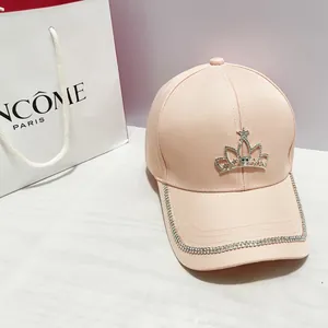 Dettaglio del cappellino rosa con corona di strass e bordo di cristalli luccicanti