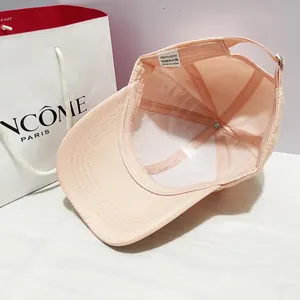 Dettaglio interno del cappellino rosa con etichetta in poliestere e fibbia metallica