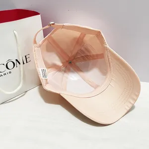 Dettaglio del cappellino rosa che mostra la fodera in poliestere e la fibbia in metallo