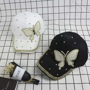 Fashion baseball caps in black and white with pearl butterfly and rhinestone embellishments