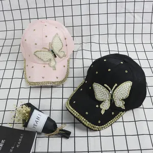 Detailed view of fashion baseball caps with pearl butterfly and gold rivets