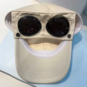 Detail of cream canvas goggles baseball cap with metal rivets and dark lenses