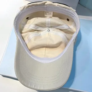 Detail of beige cotton baseball cap interior showing stitching and 56-58cm size