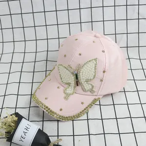 Close-up of pink fashion baseball cap with pearl butterfly patch and golden rhinestones
