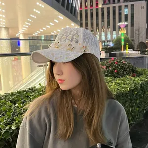 Détail de la casquette en dentelle léopard avec chaîne en résine et visière incurvée