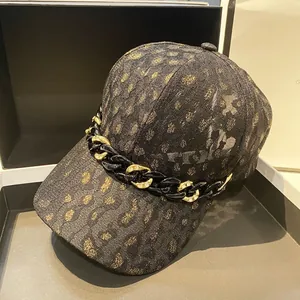 Gros plan détaillé de la casquette léopard avec chaîne dorée et détails strass