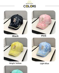 Détail du logo R en strass et bordure scintillante sur casquettes tie-dye noir et rose