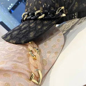 Détail de casquette léopard avec broderie métallique et chaîne à strass chic