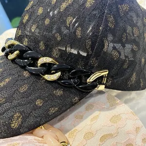 Vue rapprochée du tissu jacquard léopard avec chaîne dorée décorative et strass brillants