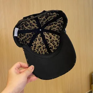 Vue détaillée de la doublure léopard et de l'étiquette d'entretien de la casquette noire