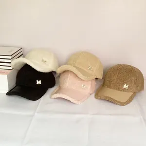 Detail view of winter lambswool baseball caps in five colors with gold M metal logo