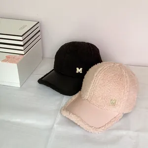 Sherpa baseball cap with leather brim and golden M logo in pink and black colors