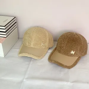 Plush lamb wool baseball caps with leather brim and M-logo in beige and brown colors